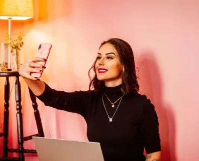 Influencer taking a selfie with a laptop, symbolizing Pakistan’s new 5% tax on digital content creators.