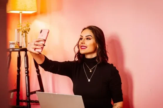 Influencer taking a selfie with a laptop, symbolizing Pakistan’s new 5% tax on digital content creators.