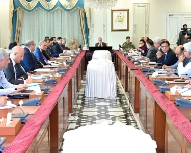 Government officials and ministers seated around a long conference table in Islamabad, discussing the extension of austerity measures and revised business hours until June 30, 2026.