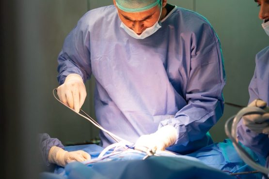 Bariatric surgeon performing a procedure in an operating room, representing medical and surgical treatment options for obesity.