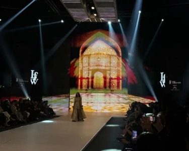 LAAM Fashion Week Season 2 Day 2 runway show in Lahore featuring a model in traditional attire against an illuminated architectural backdrop celebrating Pakistani fashion and heritage.